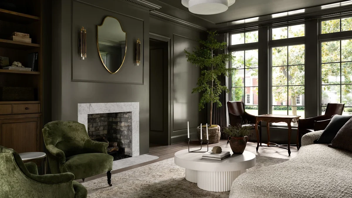 A living room with deep green painted walls and paneling, a marble fireplace and velvet chairs